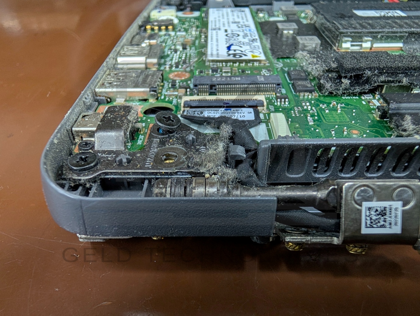 Close-up of fractured plastic around brass threaded insert on Lenovo IdeaPad 3 hinge mount