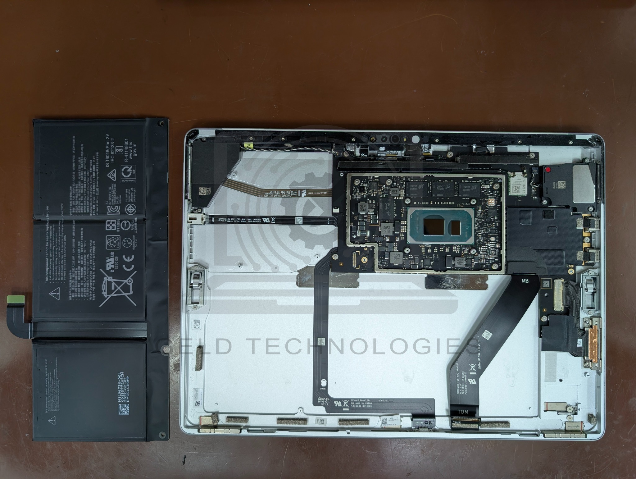 Original Surface Pro 8 battery removed beside the open chassis