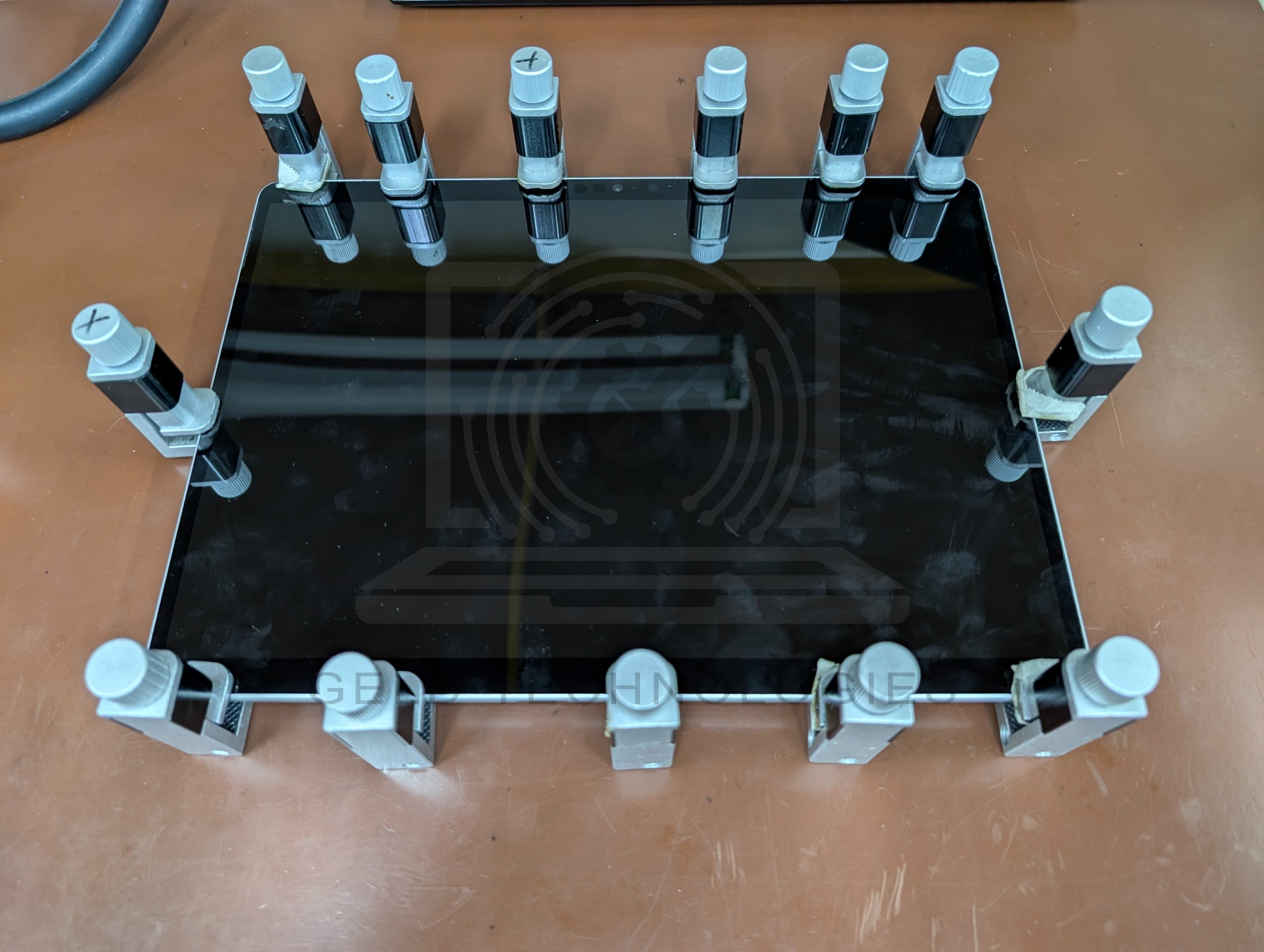 Surface Pro 8 display held with clamps during screen rebonding